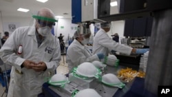 A supervisor inspects new face masks being made at a new factory in Mexico City, May 21, 2020. 