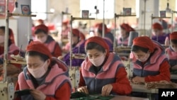 FILE - Workers produce masks for protection against the new coronavirus, at the Songyo Knitwear Factory in Pyongyang, Feb. 6, 2020.