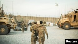 FILE - A U.S. soldier from the 3rd Cavalry Regiment walks with the unit's Afghan interpreter before a mission near forward operating base Gamberi in the Laghman province of Afghanistan, Dec. 11, 2014. 