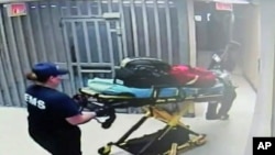 In this July 13, 2015, frame taken from video provided by the Waller County Sheriff's Department from a motion-operated camera, emergency personnel carry a gurney near Sandra Bland's jail cell, at the Waller County jail in Hempstead, Texas.