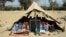 Afghan students attend a school class under a tent in Jalalabad, capital of Nangarhar province, Dec. 16, 2015. According to Afghan Ministry of Education estimates, around 33,000 students have been deprived of education in 58 schools in the Achin, Haskamena, and Kot districts of Nangarhar province.