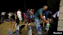 People collect water from a spring in the Newlands suburb as fears over the city's water crisis grow in Cape Town, South Africa, Jan. 25, 2018. 