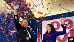 Kandidat Demokrat untuk Senator AS Doug Jones dan istrinya Louise melambai ke pendukung sebelum berbicara pada hari Selasa, 12 Desember 2017 di Birmingham, Alabama.