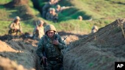 Armenian soldiers take their position on the front line in Tavush region, Armenia, July 14, 2020. Skirmishes on the volatile Armenia-Azerbaijan border escalated Tuesday, marking the most serious outbreak of hostilities between the neighbors since 2016. 