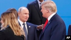 FILE - President Donald Trump, right, walks past Russia's President Vladimir Putin, left, as they gather for a group photo at the start of the G-20 summit in Buenos Aires, Argentina, Nov. 30, 2018.