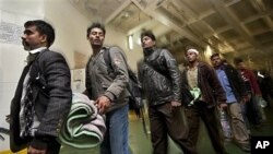 Some of the 1,200 migrant workers who were evacuated from Misrata by boat, many suffering from dehydration and needing medical attention, leave the boat after it arrived at the port in Benghazi, Libya, April 15, 2011
