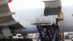 FILE - In this photo released by the Taiwan Centers for Disease Control, workers unload COVID-19 vaccines from a China Airlines cargo plane from Memphis that arrived at the airport outside Taipei in Taiwan, June 20, 2021.
