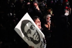 FILE - Tabitha Poppins chants in front of the Multnomah County Sheriff's Office during a protest against racial inequality and police violence on Aug. 7, 2020 in Portland, Ore.