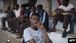 Sudanese refugees, who fled from the clashes between forces loyal to the internationally recognized Government of National Accord and forces loyal to strongman Khalifa Haftar, sit together at a school in Libya's capital, Tripoli, on April 24, 2019.