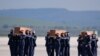 Spanish air force personnel carry the coffins with the bodies of Spanish journalists David Beriain and Roberto Fraile and Irish ONG chief Rory Young, killed in eastern Burkina Faso, after arriving in the Torrejon de Ardoz air base on April 30, 2021. 