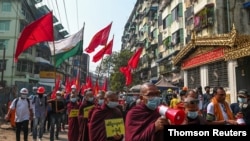 Demonstrators rally against the military coup after riot police officers used tear gas to disperse a crowd that held a protest the previous night in Yangon's Tamwe neighborhood in Myanmar, Feb. 26, 2021.