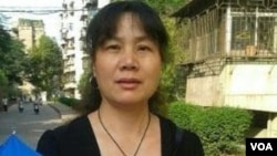 Liu Ping holds an umbrella with slogans of the New Citizens’ Movement.