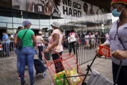 FILE - Residents wait in line to collect fresh produce and shelf-stable pantry items outside Barclays Center as Food Bank for New York City provides assistance to those in need due to the COVID-19 pandemic, Sept. 10, 2020, in New York.