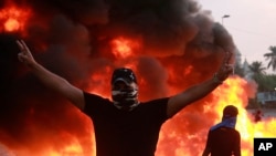 An anti-government protester flashes the victory sign during a demonstration in Baghdad, Iraq, Oct. 3, 2019. 