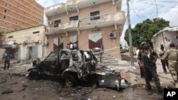 FILE - A Somali soldier stands on guard next to a destroyed car near a popular mall after a car bomb attack in Mogadishu, Somalia, July 30, 2017. The Somalia-based extremist group al-Shabab often carries out deadly bombings in Mogadishu. 