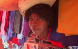 This market vendor says hand-washing and avoiding touching your face can keep you healthy, March 12, 2020. (Matiado Vilme/VOA)