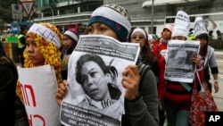 Para pekerja domestik dan pendukung mereka memegang gambar pembantu rumah tangga asal Indonesia, Erwiana Sulistyaningsih yang berusia 23 tahun dan disiksa secara brutal oleh majikannya di Hong Kong. (Foto: Dok)