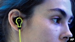 A model wears SMS Audio BioSport In-Ear Headphones at the Intel booth during the International CES, in Las Vegas, Jan. 6, 2015.