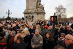 People watch the funeral convoy as France prepares to pay homage to the 13 French soldiers killed in Mali, Dec.2, 2019 in Paris.