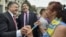 Ukrainian President Petro Poroshenko, left, and then-governor of Odessa region Mikheil Saakashvili, center, are greeted by a local resident near the regional state administration in Odessa, Ukraine, May 30, 2015.