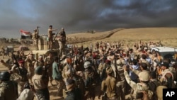 ក្រុម​ទាហាន​អ៊ីរ៉ាក់​ លើក​អាវុធ​របស់ពួកគេ​ដើម្បី​អបអរ​សាទរ​នៅ​ជាយក្រុង​ Mosul។ ពួក​គេ​​ត្រៀមចូល​ក្នុង​ក្រុង​ Mosul នៅល្ងាច​ថ្ងៃ​ចន្ទ។