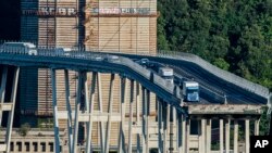 Cars and trucks are left on a section of the collapsed Morandi highway bridge in Genoa, northern Italy, Aug. 15, 2018. 