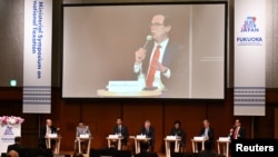U.S. Secretary of Treasury Steven Mnuchin, right, on podium, delivers a speech during the G20 Ministerial Symposium on International Taxation in the G20 Finance Ministers and Central Bank Governors meeting in Fukuoka, Japan, June 8, 2019. 