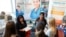 FILE - Job seekers listen to a recruiter at the Colorado Hospital Association job fair in Denver, Colorado, Oct. 4, 2017. 