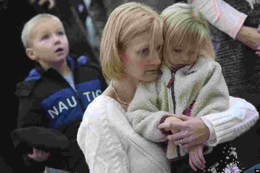Barbara Wells of Shelton, Conn., holds her daughter Olivia, 3, as she pays her respects Dec. 17, 2012 at one of the makeshift memorials for the victims of the Sandy Hook Elementary School shooting in Newtown, Conn.