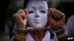 FILE - A handcuffed women attends a rally to protest the Venezuelan July 28 disputed presidential election in Panama City, Sept. 28, 2024. The rally was one of several held outside Venezuela.
