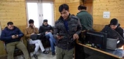 FILE - In this Jan. 30, 2020, photo, Kashmiri journalists browse the internet on their mobile phones inside the media center set up by government authorities in Srinagar, Indian-controlled Kashmir.