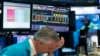 A trader holds his hand to his head after trading was halted for the day at the New York Stock Exchange, March 18, 2020, in New York. Remove
