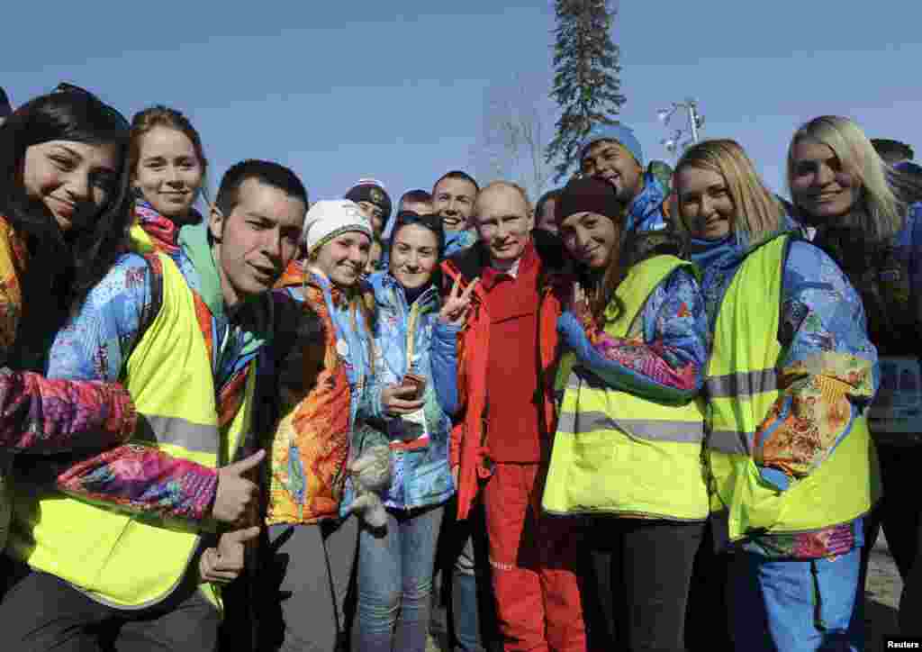 Russian President Vladimir Putin poses for a photograph with volunteers during his visit to watch the men&#39;s&nbsp;cross country skiing relay during the Sochi 2014 Olympic Winter Games at Laura Cross-Country Ski and Biathlon Center near Krasnaya Polyana, Russia, Feb. 16, 2014.