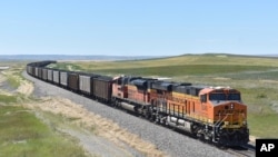 FILE - A BNSF Railway train hauling carloads of coal from the Powder River Basin of Montana and Wyoming is seen east of Hardin, Mont., on July 15, 2020. 