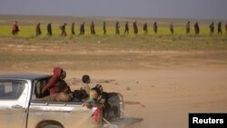 FILE - Children from the Yazidi community, who were recently freed after being captured by Islamic State fighters, ride on a back of a truck near Baghouz, Deir el-Zour province, Syria, March 6, 2019.