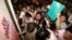 FILE - Filipino job seekers look at job openings posted on a board inside a Philippine Overseas Employment Agency (POEA) in Manila.