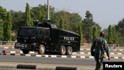 Wani mutum na wucewa ta kusa da motar 'yan sanda