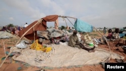 Horoun Dadoum, 80, a Sudanese man who fled the conflict in Murn in Sudan's Darfur region, sits with his wife Fatma Abdelkareem, 70, by his belongings as they arrived only yesterday in Adre, Chad, July 24, 2023.
