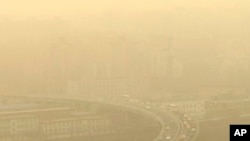 FILE - Cars drive along a highway photographed through a glass window during a dust storm amid heavy pollution in Beijing, March 10, 2023.