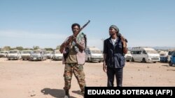 Des membres de la milice Amhara posent pour un portrait à l'entrée du 5e bataillon du commandement nord de l'armée éthiopienne à Dansha, en Éthiopie, le 25 novembre 2020.