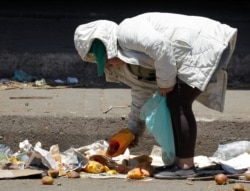 Una mujer busca verduras en buen estado en un mercado en Bogotá. 7 de marzo de 2012. América Latina es una de las regiones más desiguales del mundo, según indican varios estudios.