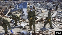 Anggota tentara Jepang dikerahkan untuk menyisir para korban gempa dan tsunami yang belum ditemukan (24/4).