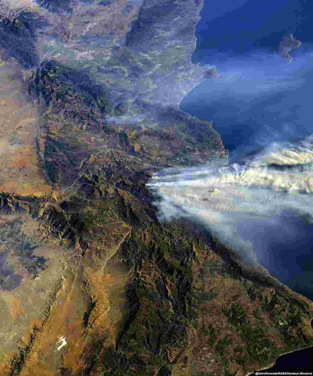 A photo taken from the International Space Station and moved on social media by astronaut Randy Bresnik shows smoke rising from wildfire burning in Southern California, Dec. 6, 2017.