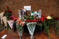 Flowers and tributes are placed outside the Iranian Embassy in Kyiv, Ukraine, Jan. 10, 2020, with a poster that reads: "Tehran - Kyiv, we're mourning" for the victims of the Ukrainian plane that crashed on the outskirts of Tehran, Iran.