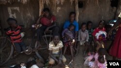 FILE - South Sudanese refugees who fled fighting between government and rebel forces wait in the shade of a dilapidated church near Aba, South Sudan, to be taken to a nearby refugee camp on Dec. 19, 2017.