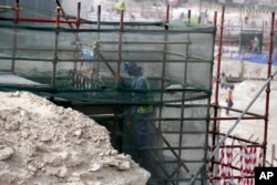 FILE - a foreign worker climbs scaffolding at the Al-Wakra Stadium that is under construction for the 2022 World Cup in Doha, Qatar, May 4, 2015,