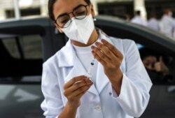 A health care worker prepares a dose of China's Sinovac Biotech COVID-19 vaccine at a vaccination site in the Sambadrome, in Rio de Janeiro, Brazil, Feb. 6, 2021.