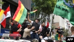 Luis Fernando Camacho (C), un líder de la oposición boliviana, ondea una bandera nacional boliviana en La Paz el 10 de noviembre de 2019, luego de entregar una carta de renuncia preescrita en el Palacio Quemado (antiguo Palacio de Gobierno) para el expresidente Evo Morales.