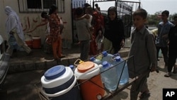Pakistani boy carries clean water supplies from tanker, Karachi, July 2011 (file photo).