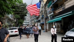 Massa berbaris dengan mengibarkan bendera federal saat mendukung emerintah Persatuan Nasional atau National Unity Government (NUG) yang baru-baru ini diumumkan di Yangon, Myanmar, 18 April 2021. (Foto: Reuters)